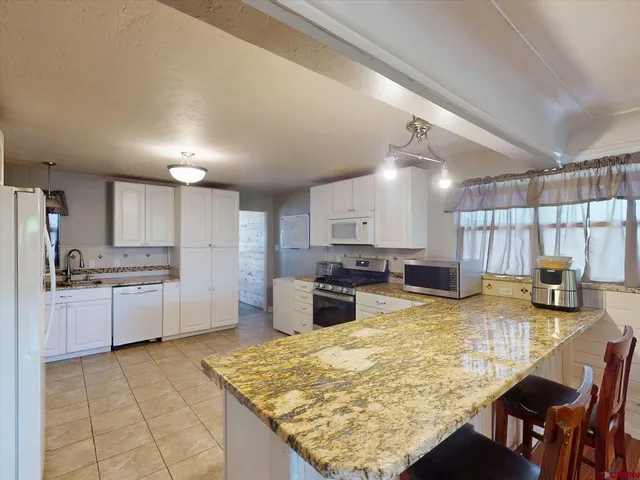 a kitchen with stainless steel appliances granite countertop a stove oven and a refrigerator
