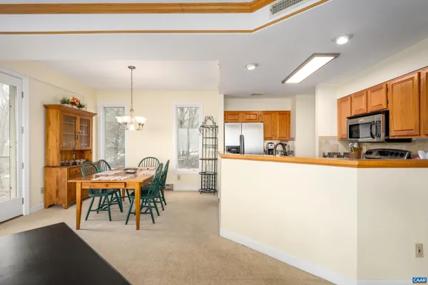 a view of a dining room with furniture a chandelier and wooden floor