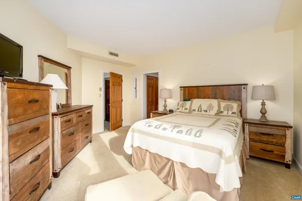 a bedroom with a bed and a flat screen tv