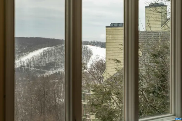 a living room with a fireplace cabinet and a large window