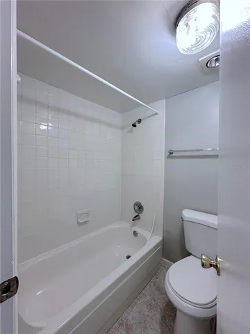 a white toilet sitting next to a bath tub
