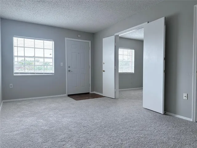 an empty room with windows and closet