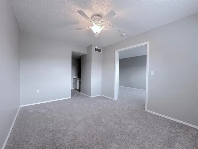 a view of an empty room with a ceiling fan