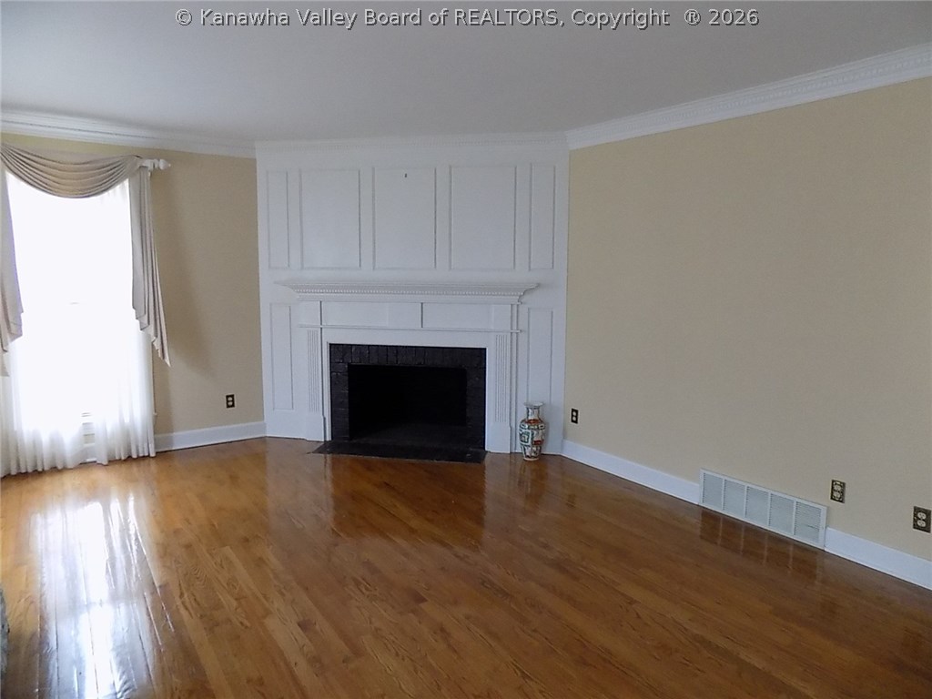 134 East Ridge Road Charleston, WV 25314 - Photo 4 of 30 A wood burning fireplace with floor to ceiling paneled surround is the focal point in the light-filled living room.
