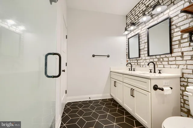 a bathroom with a double vanity sink mirror and toilet