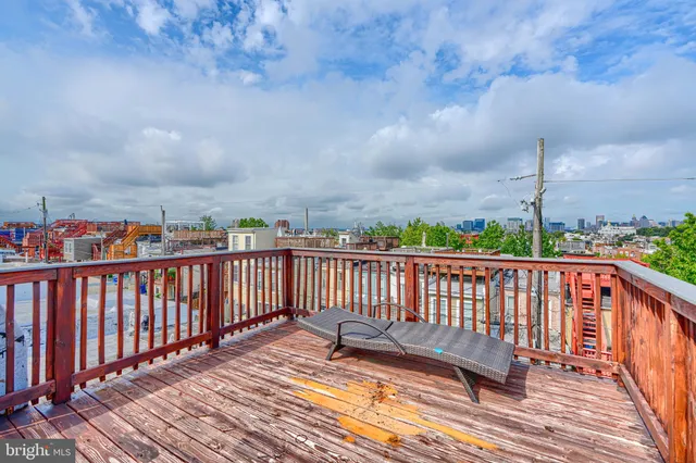 a view of balcony with wooden floor & fence
