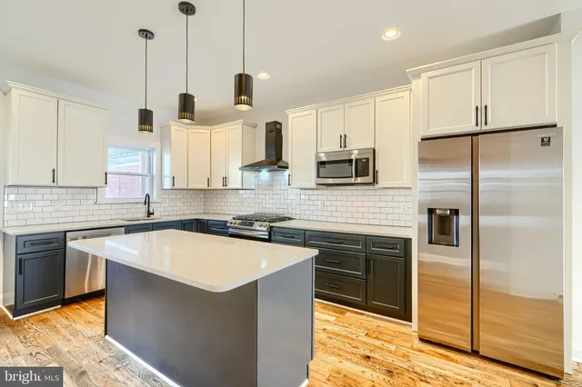 a kitchen with stainless steel appliances granite countertop a refrigerator a sink and a stove