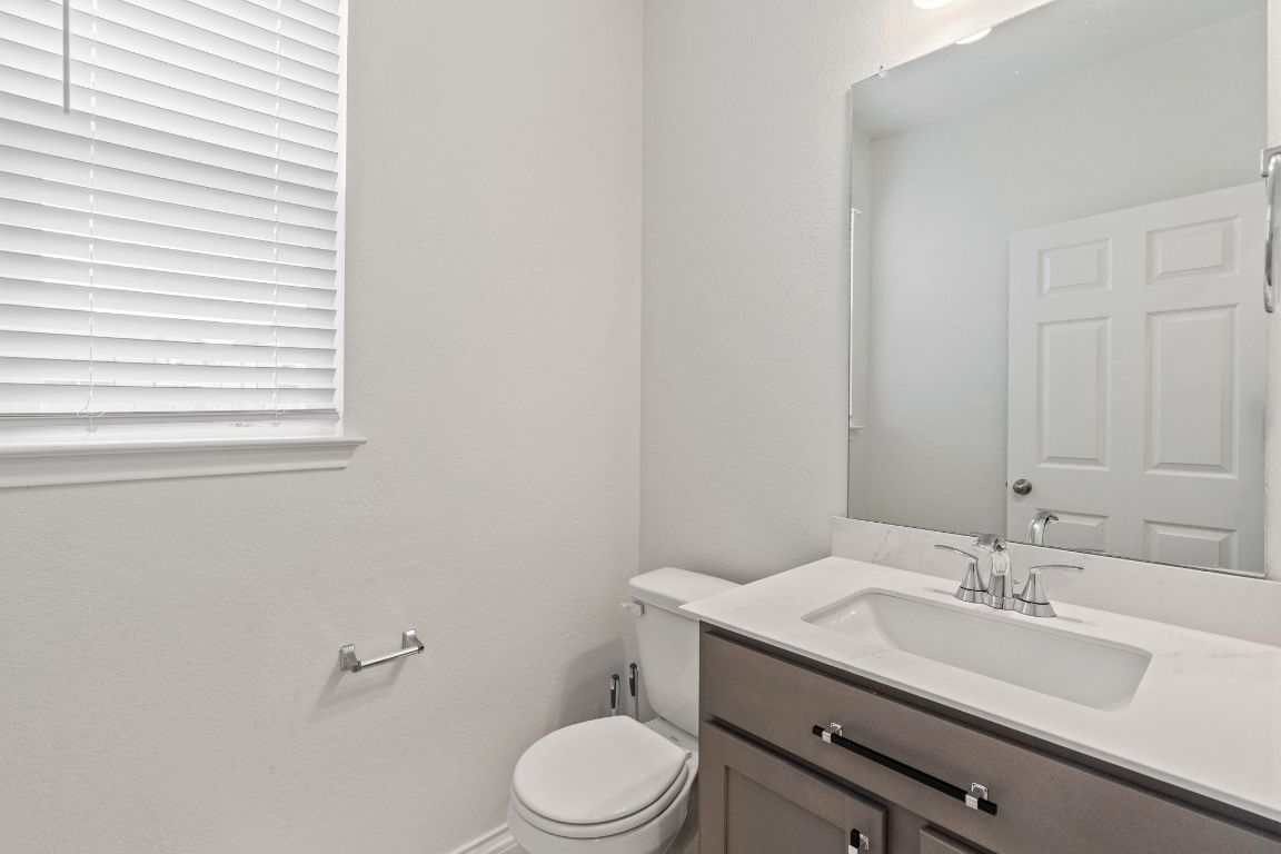 7808 Lawford Way Austin, TX 78744 - Photo 18 of 40 Half bath featuring vanity and a textured wall