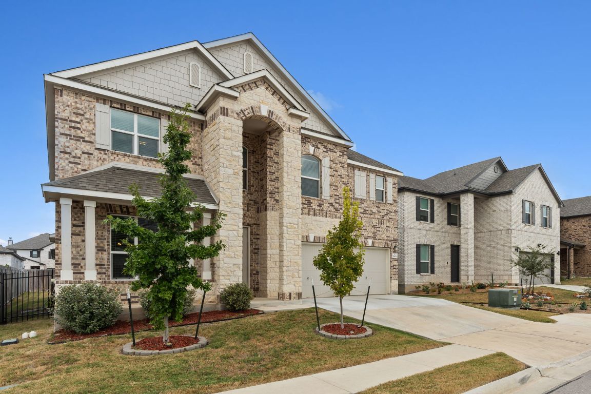 7808 Lawford Way Austin, TX 78744 - Photo 2 of 40 View of front facade featuring driveway, an attached garage, and brick siding