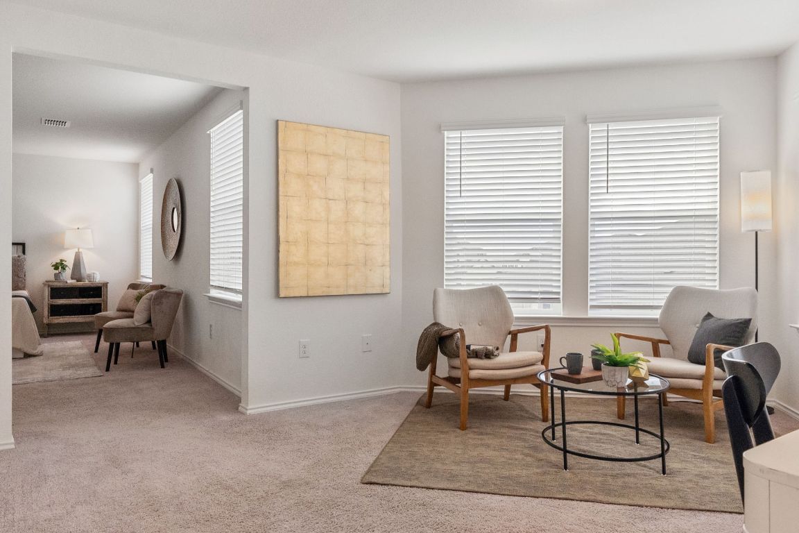 7808 Lawford Way Austin, TX 78744 - Photo 21 of 40 Living area featuring light carpet and baseboards