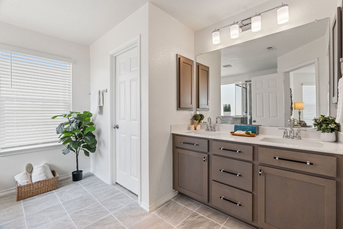 7808 Lawford Way Austin, TX 78744 - Photo 23 of 40 Full bathroom with double vanity and a shower stall