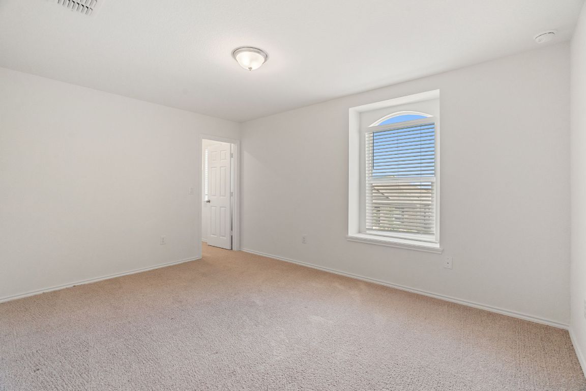 7808 Lawford Way Austin, TX 78744 - Photo 29 of 40 Empty room with baseboards and light colored carpet