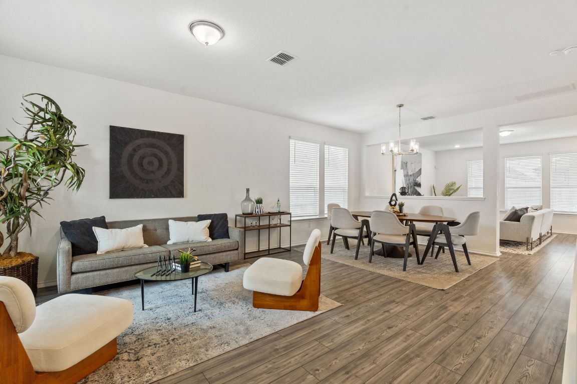 7808 Lawford Way Austin, TX 78744 - Photo 4 of 40 Living room with healthy amount of natural light, wood finished floors, and a chandelier