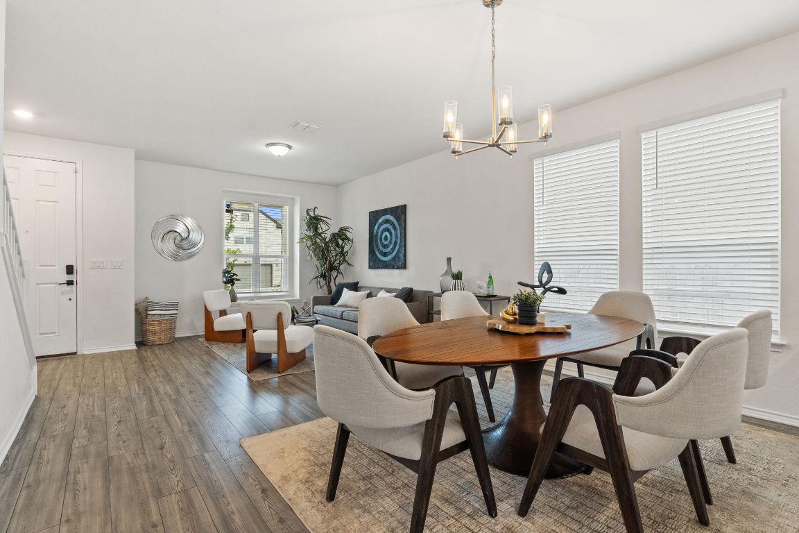 7808 Lawford Way Austin, TX 78744 - Photo 9 of 40 Dining room with wood-type flooring and a chandelier