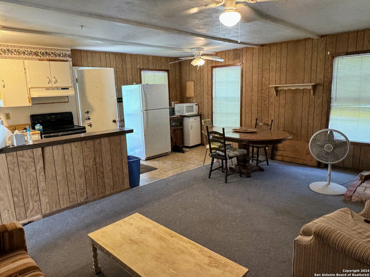 201 Cypress Bluff Road Pipe Creek, TX 78063 - Photo 15 of 16 a kitchen with stainless steel appliances granite countertop a refrigerator a stove and a dining table with wooden floor