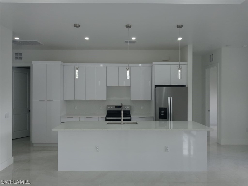 810 Homestead Road South Lehigh Acres, FL 33974 - Photo 4 of 18 a kitchen with stainless steel appliances a refrigerator and a stove top oven