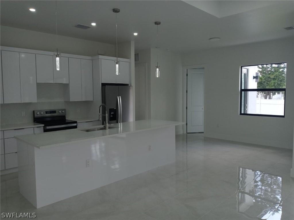 810 Homestead Road South Lehigh Acres, FL 33974 - Photo 7 of 18 a kitchen with stainless steel appliances a refrigerator a sink a stove a microwave and cabinets