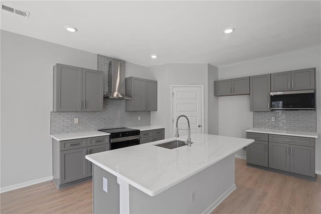 3650 River Rock Road Lithonia, GA 30038 - Photo 12 of 42 a kitchen with a sink dishwasher a stove and a refrigerator with wooden floor