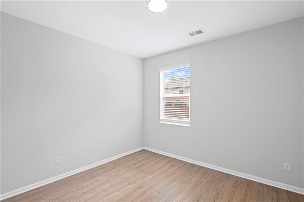3650 River Rock Road Lithonia, GA 30038 - Photo 17 of 42 an empty room with wooden floor and windows