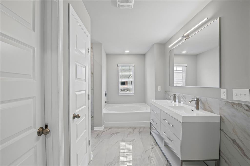 3650 River Rock Road Lithonia, GA 30038 - Photo 26 of 42 a bathroom with a sink a mirror and a bathtub