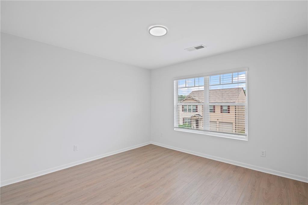 3650 River Rock Road Lithonia, GA 30038 - Photo 35 of 42 an empty room with wooden floor and windows