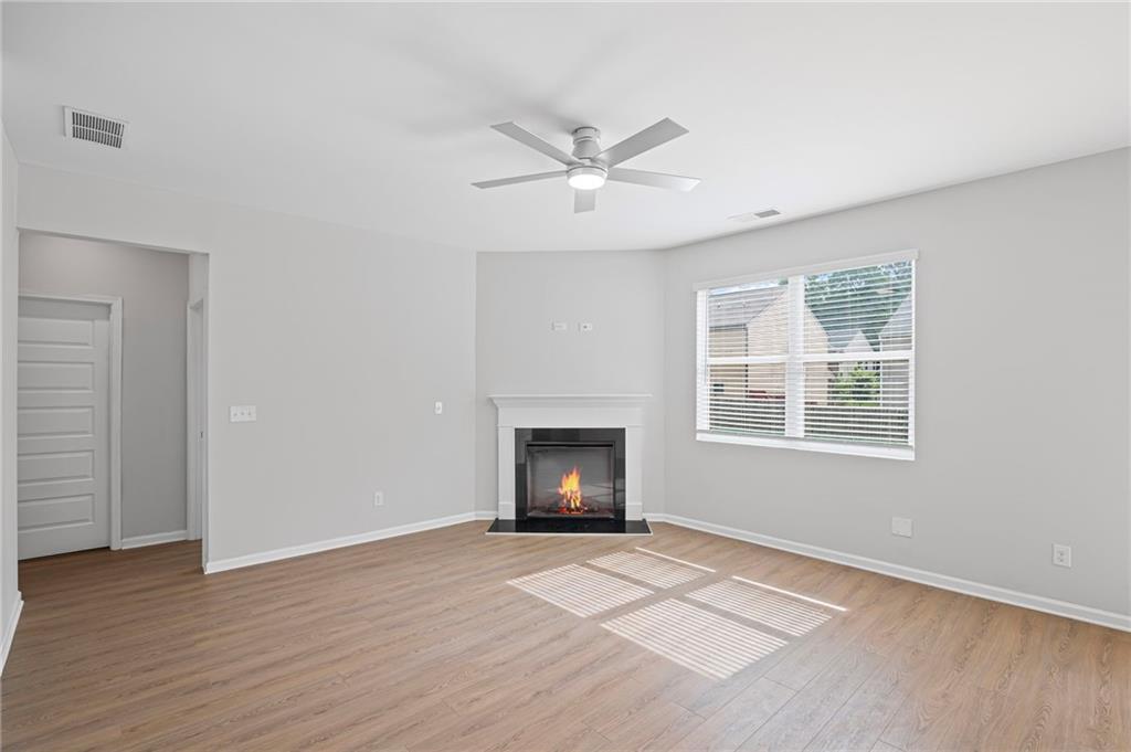 3650 River Rock Road Lithonia, GA 30038 - Photo 7 of 42 an empty room with windows and a fireplace