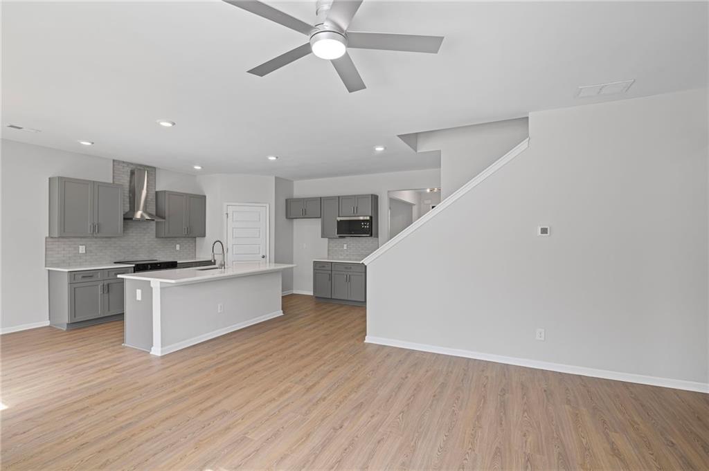 3650 River Rock Road Lithonia, GA 30038 - Photo 10 of 42 a large kitchen with a wooden floor and stainless steel appliances