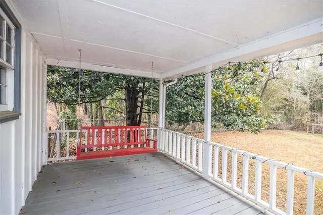 a view of a porch with wooden floor and iron fence