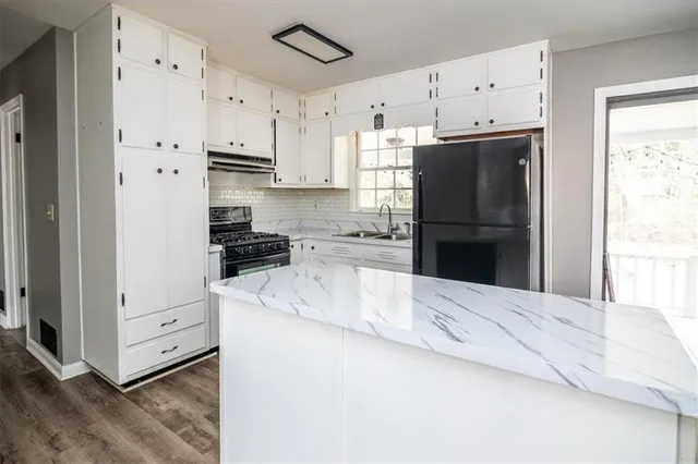 a kitchen with granite countertop a refrigerator and a stove
