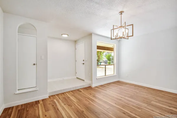 a view of empty room with wooden floor and window