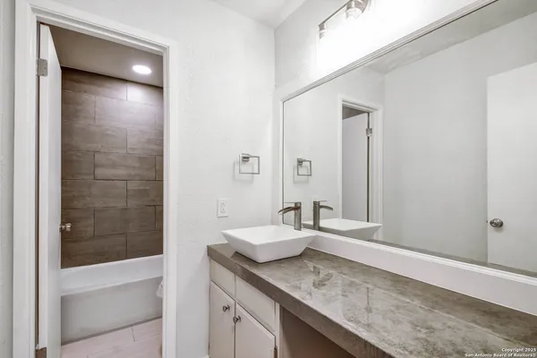a bathroom with a granite countertop sink and a mirror