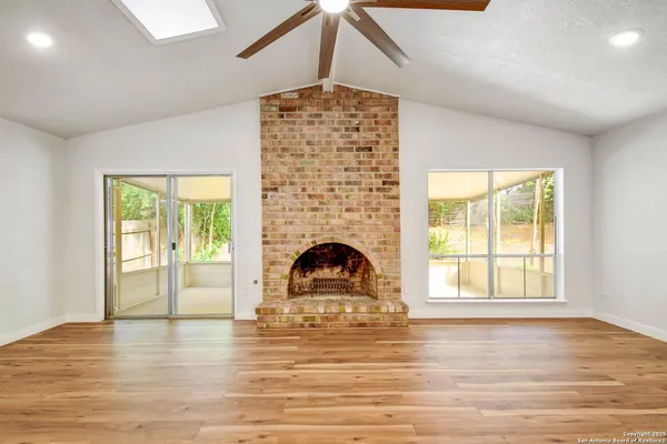 a view of empty room with wooden floor and fireplace