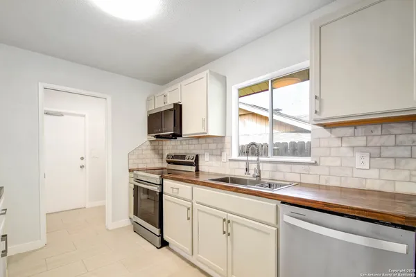 a kitchen with stainless steel appliances white cabinets and a sink