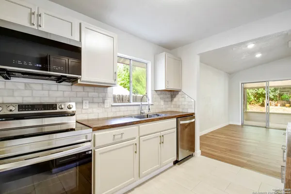 a kitchen with stainless steel appliances a stove microwave and sink