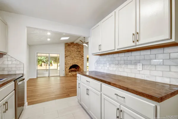 a kitchen with granite countertop white cabinets and a stove