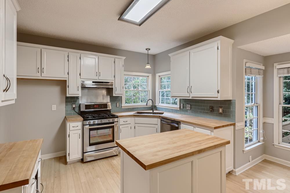 5405 Staysail Court Raleigh, NC 27613 - Photo 5 of 28 a kitchen with cabinets appliances a sink and a counter top space