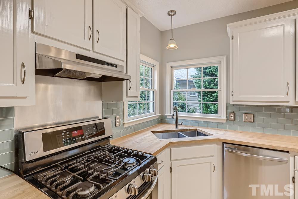 5405 Staysail Court Raleigh, NC 27613 - Photo 7 of 28 a kitchen with stainless steel appliances granite countertop a stove and a sink