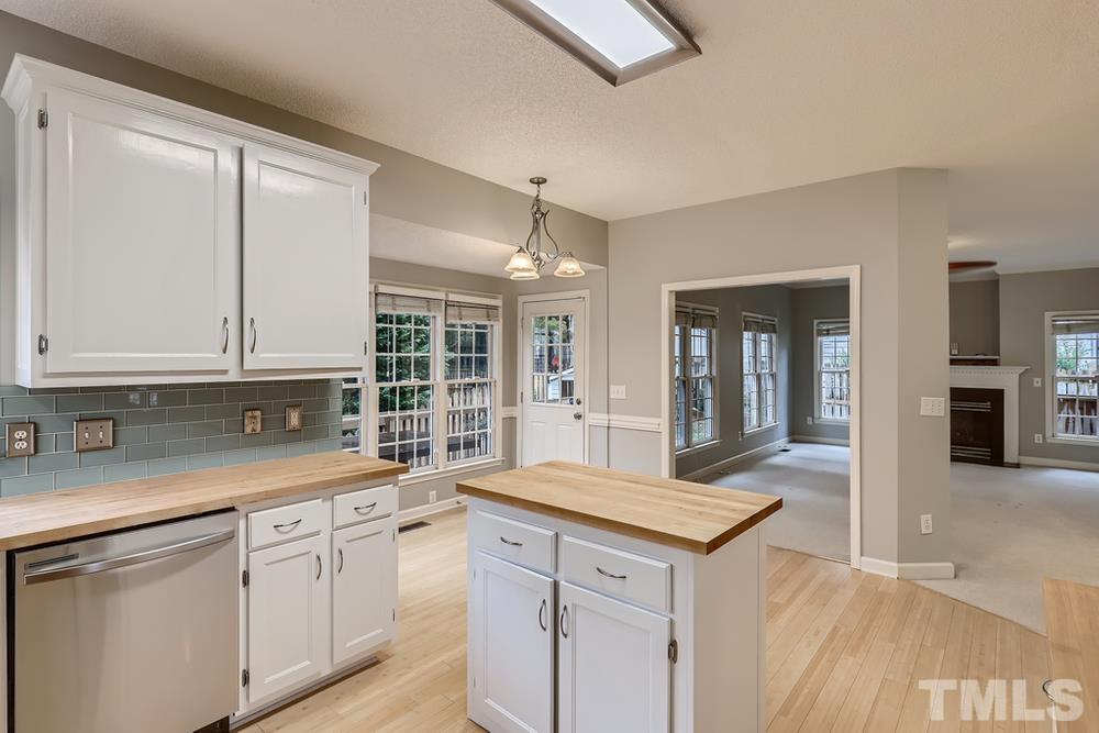 5405 Staysail Court Raleigh, NC 27613 - Photo 8 of 28 a kitchen with granite countertop a sink and dishwasher with wooden cabinets