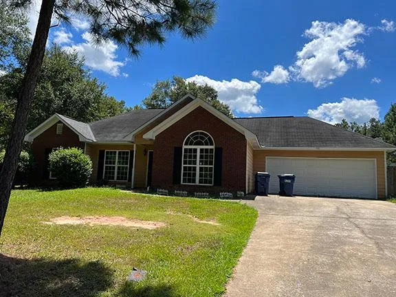 a front view of a house with yard and green space