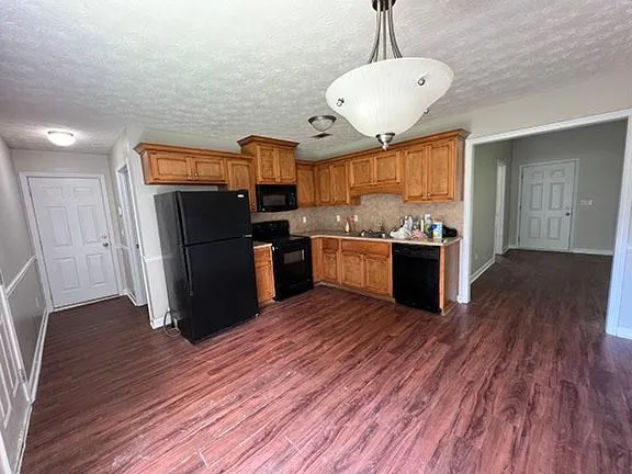 a kitchen with stainless steel appliances wooden floor and large windows