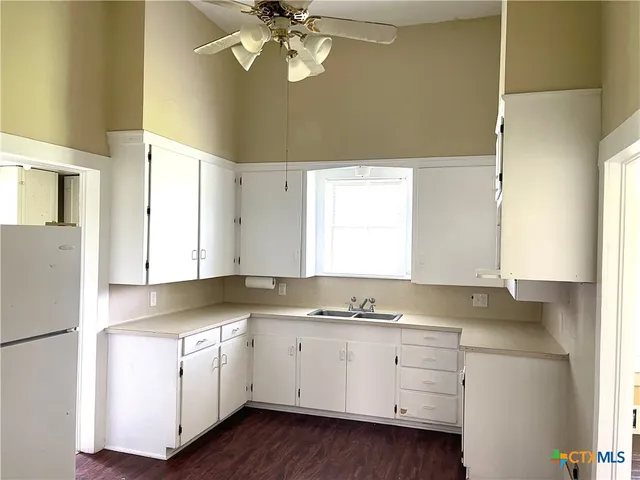 a kitchen with granite countertop white cabinets and white appliances