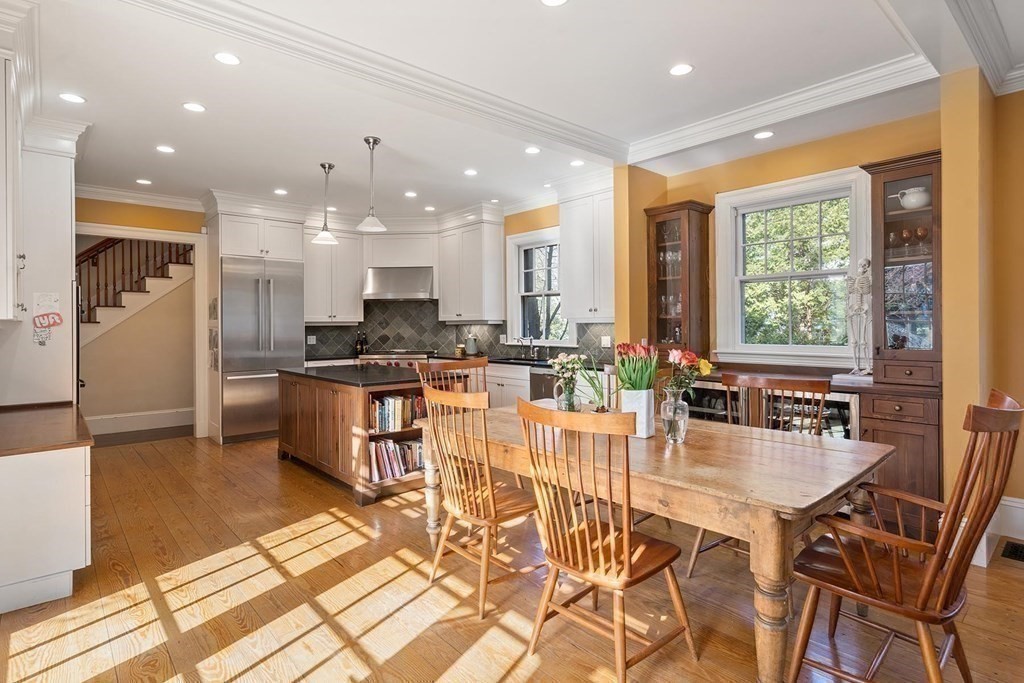 37 Circuit Road Brookline, MA 02467 - Photo 19 of 37 a kitchen with stainless steel appliances kitchen island granite countertop a stove a refrigerator a sink a dining table and chairs with wooden floor