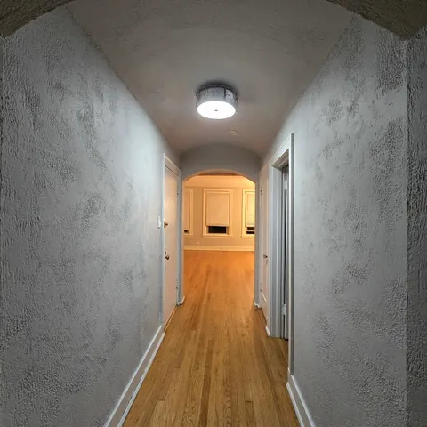 a view of a hallway with wooden floor and closet