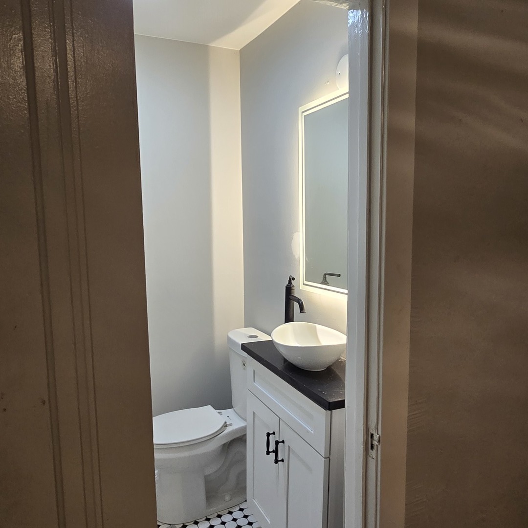7529 North Claremont Avenue, Unit 2 Chicago, IL 60645 - Photo 22 of 24 a bathroom with a toilet sink and mirror