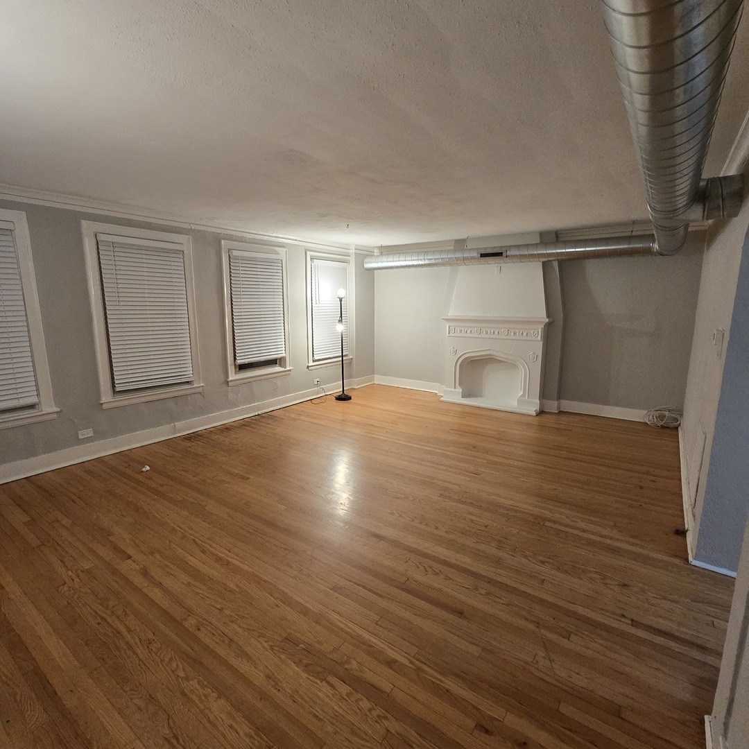 7529 North Claremont Avenue, Unit 2 Chicago, IL 60645 - Photo 4 of 24 a view of empty room with wooden floor and fan