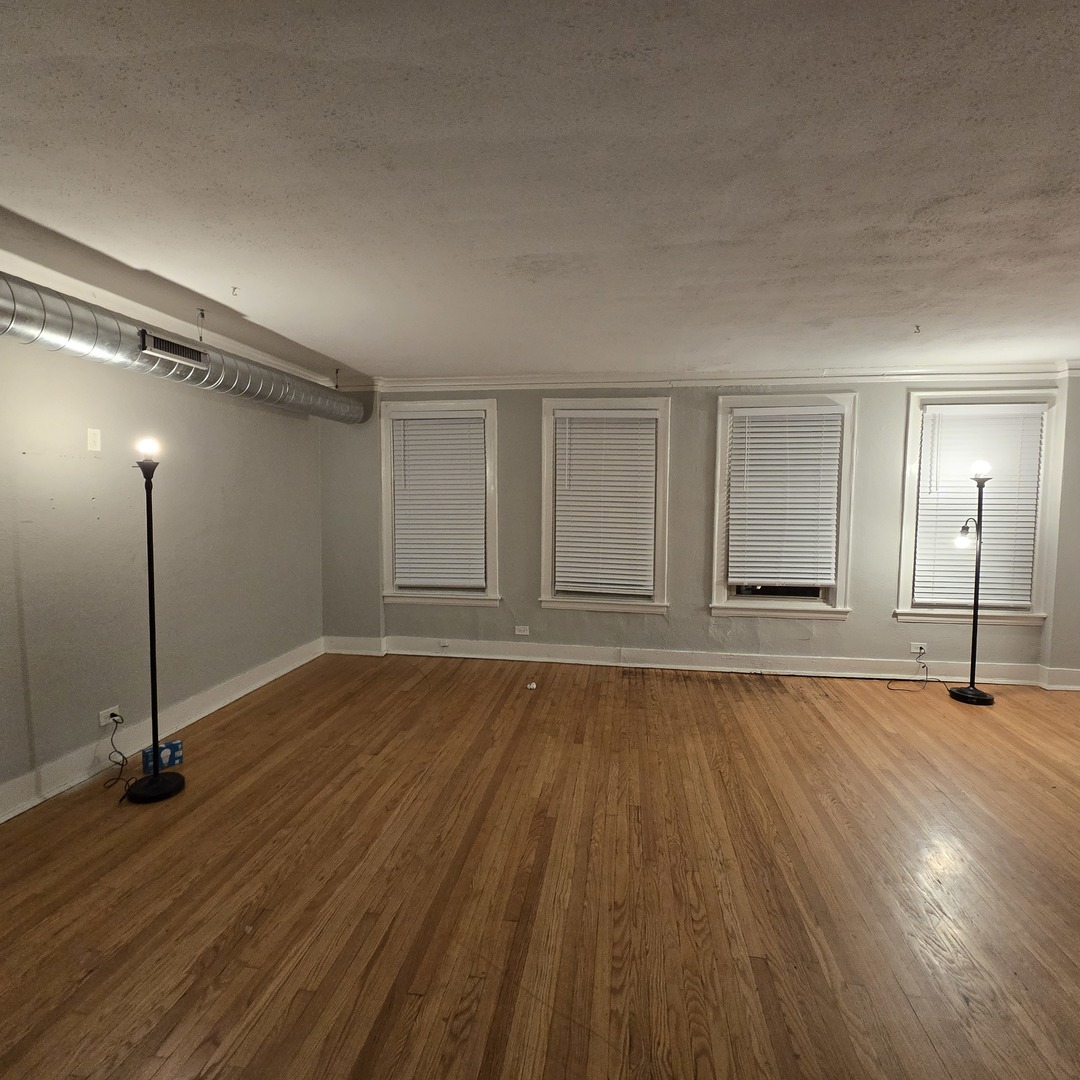 7529 North Claremont Avenue, Unit 2 Chicago, IL 60645 - Photo 5 of 24 a view of empty room with wooden floor and fan