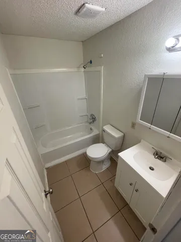 an empty room with wooden floor and ceiling fan