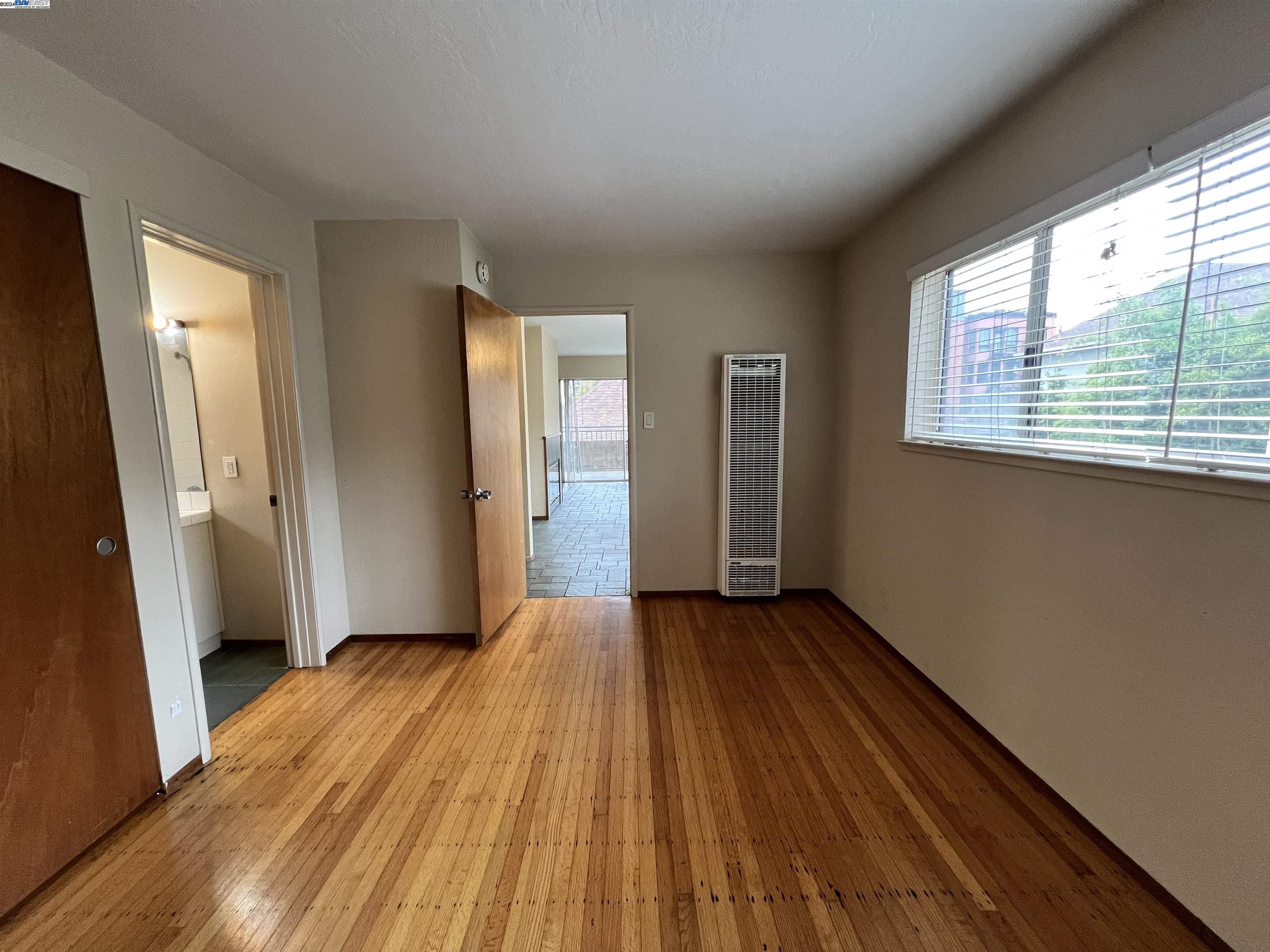 2418 Ashby Avenue, Unit B Berkeley, CA 94705 - Photo 14 of 17 a view of a livingroom with wooden floor and a window