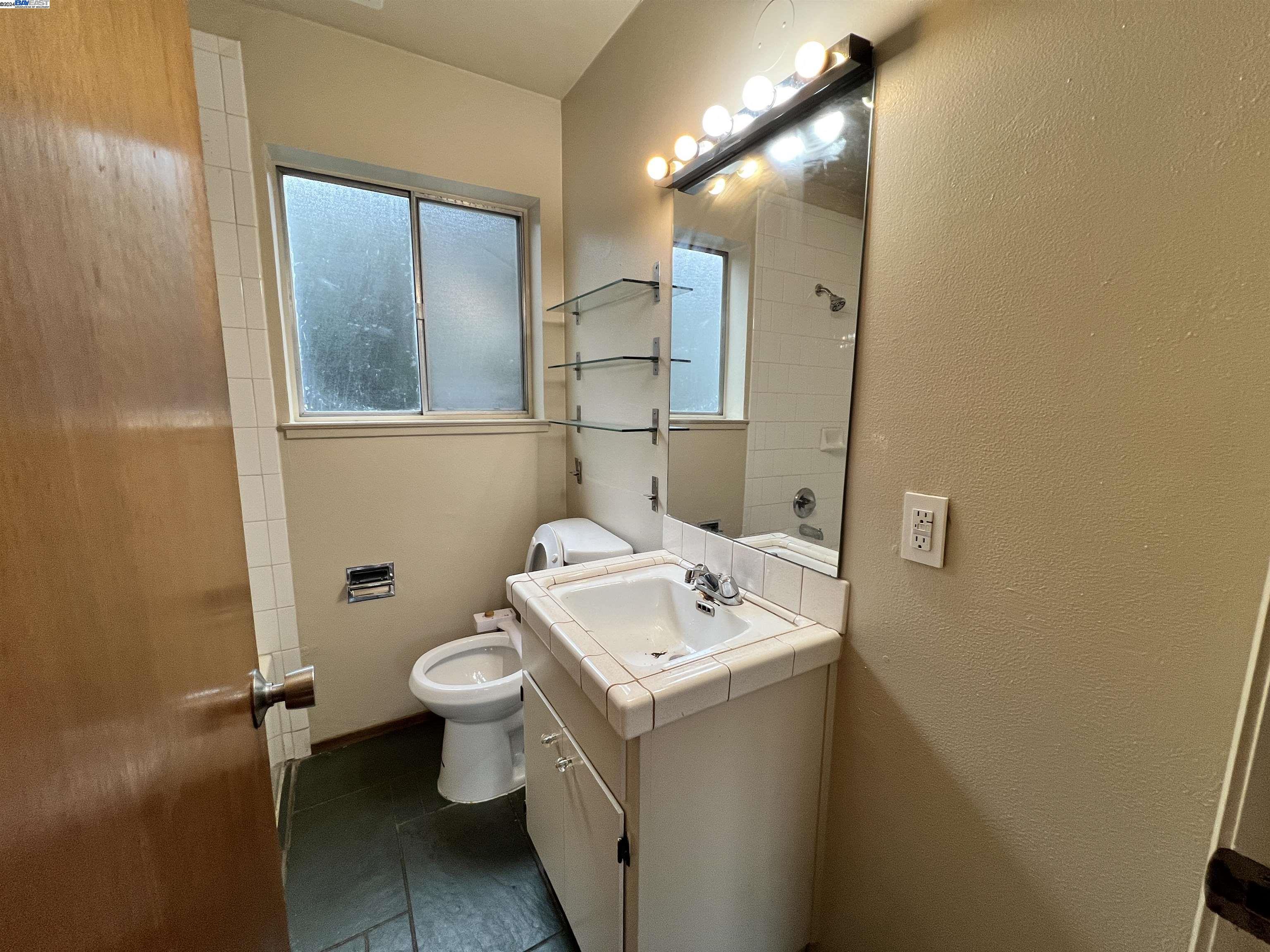 2418 Ashby Avenue, Unit B Berkeley, CA 94705 - Photo 16 of 17 a bathroom with a sink mirror toilet and vanity