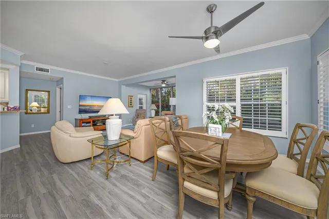 a living room with furniture a large window and wooden floor